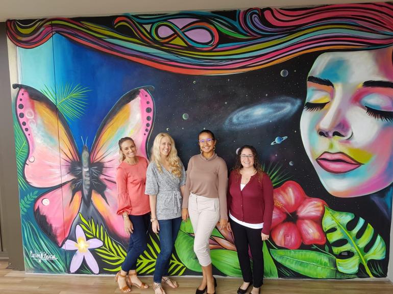 four-women-in-front-of-a-mural-at-kimpton-seafire-cayman